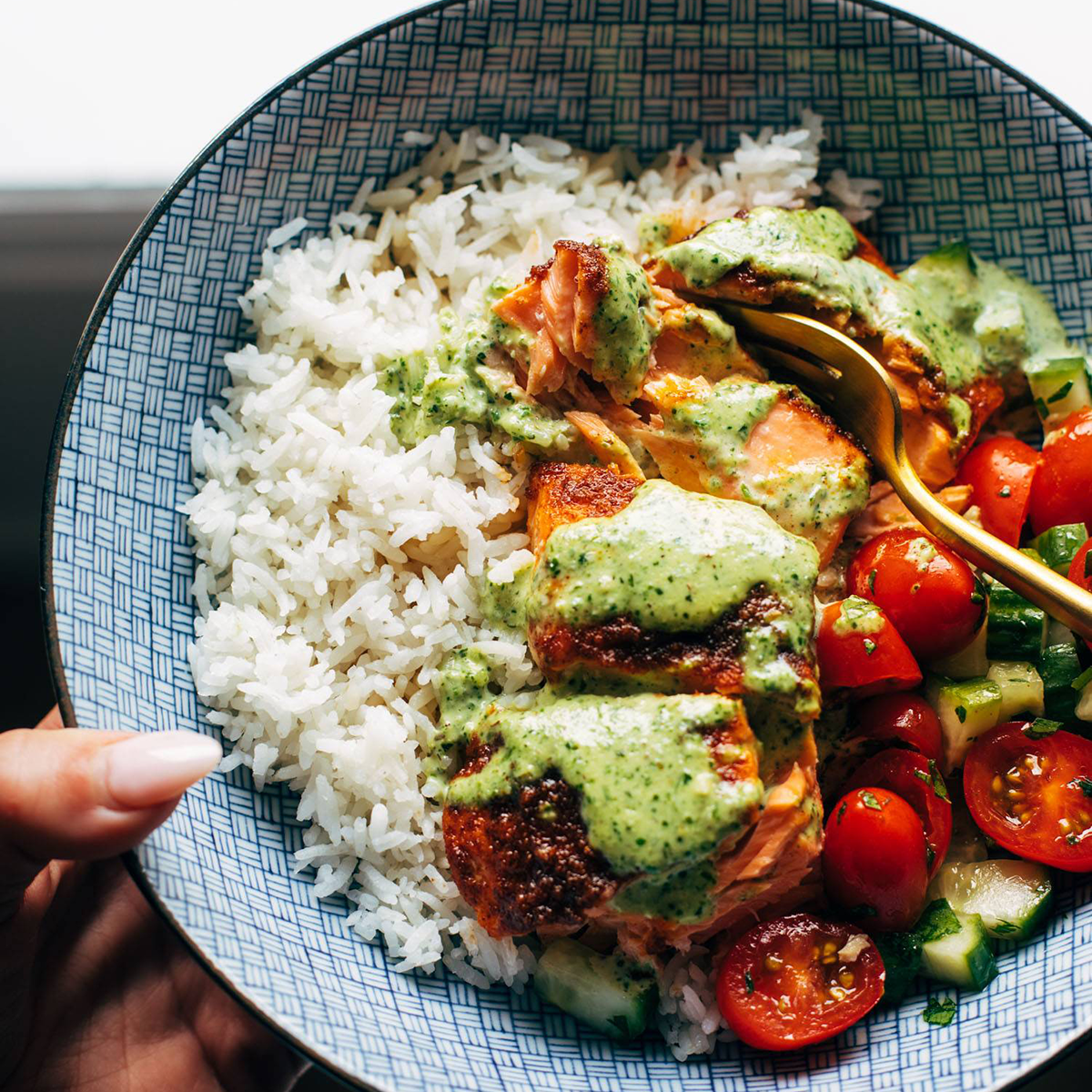 Salmon in a bowl with basil sauce on top.