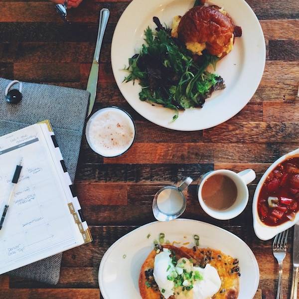 Table with plates of food and a notepad.