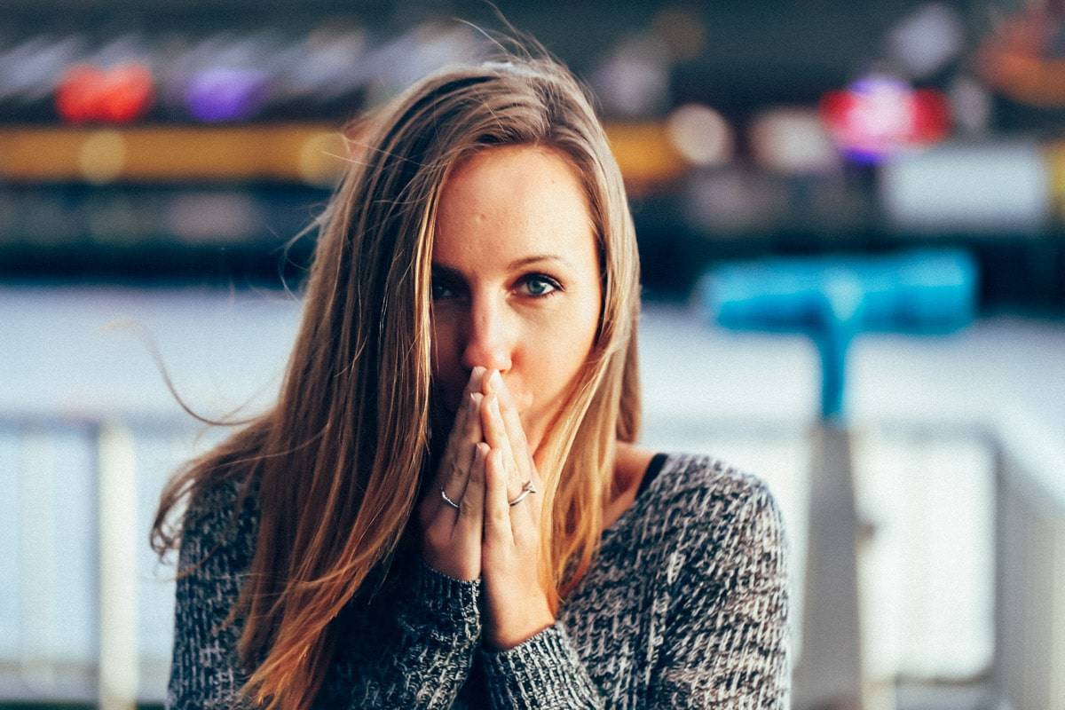 Woman with her hands to her lips.